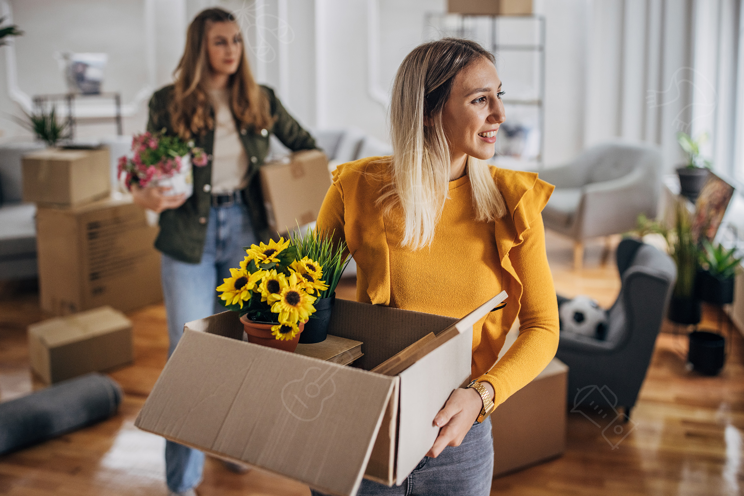 Blond kvinde som bærer på en flyttekasse og kigger smilende til højre